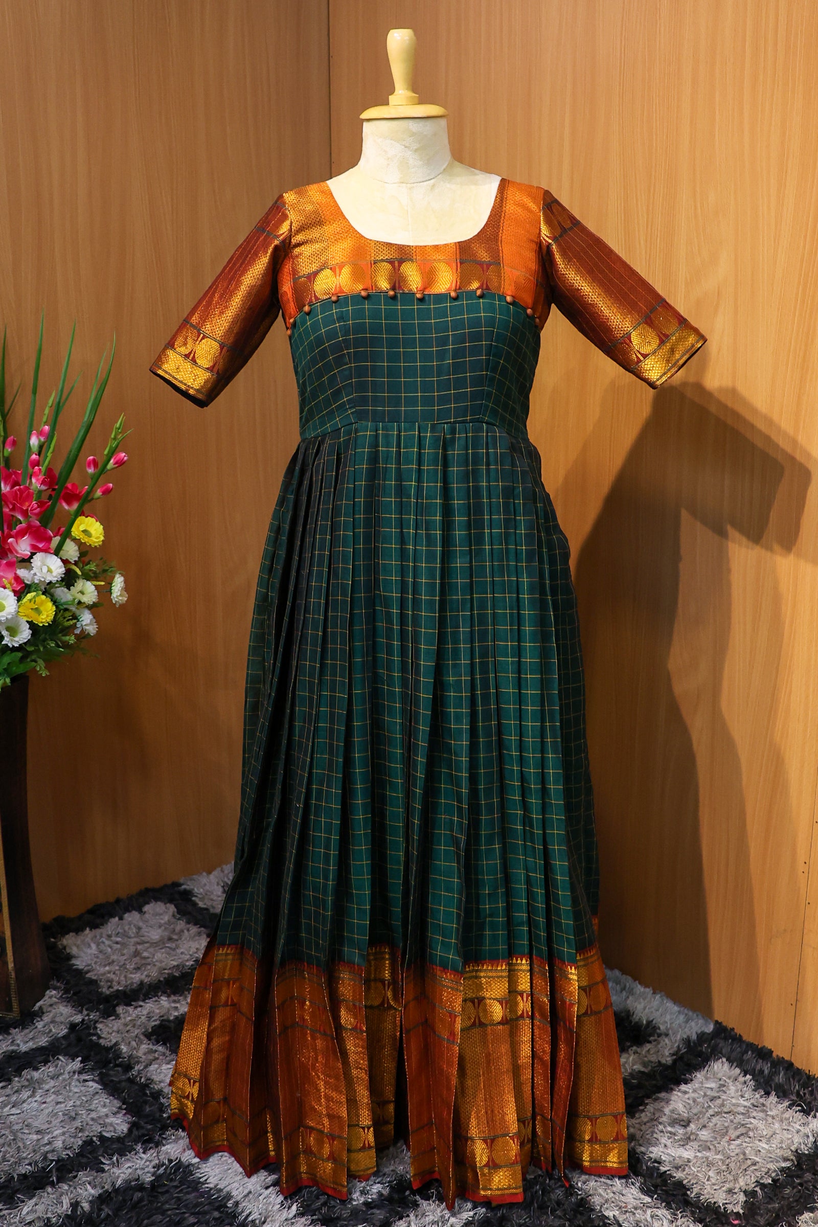 Step into timeless elegance with this handcrafted purple maxi dress by Hemqueen. Featuring gold zari accents, a flattering waist yoke, and graceful pleats, it’s perfect for weddings, poojas, and festive occasions.